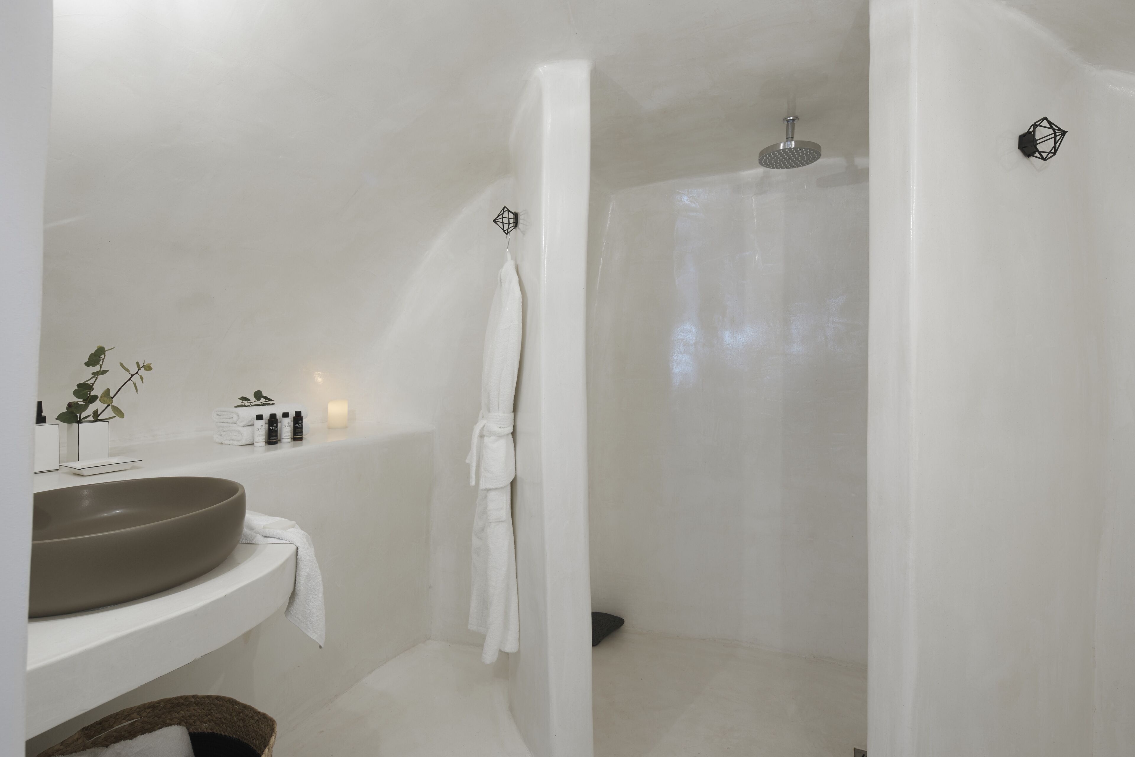 A modern bathroom with a large oval sink, a walk-in shower, and a towel rack.