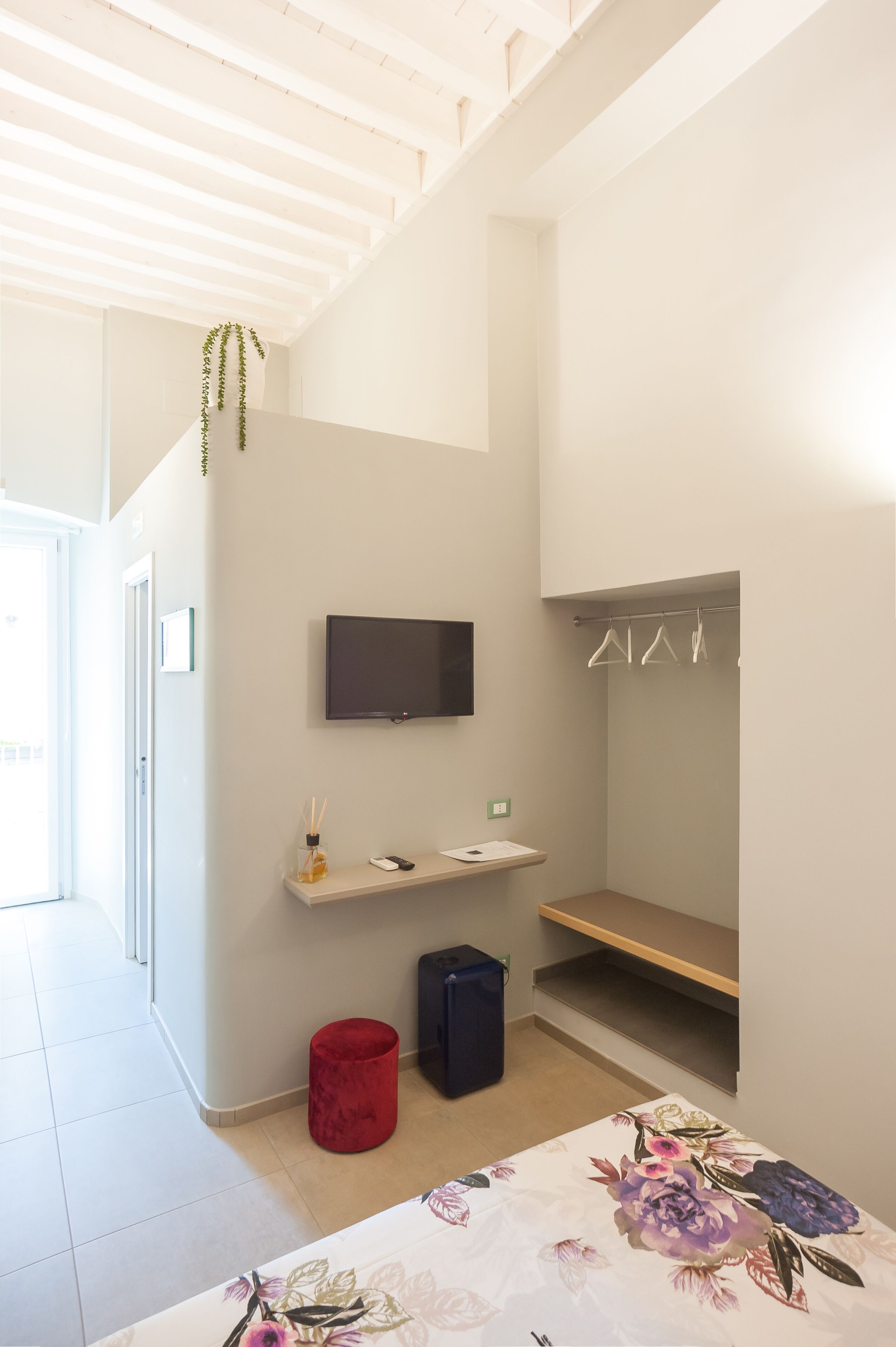 A modern bathroom with a shower, a toilet, a sink, a mirror, and a TV mounted on the wall.