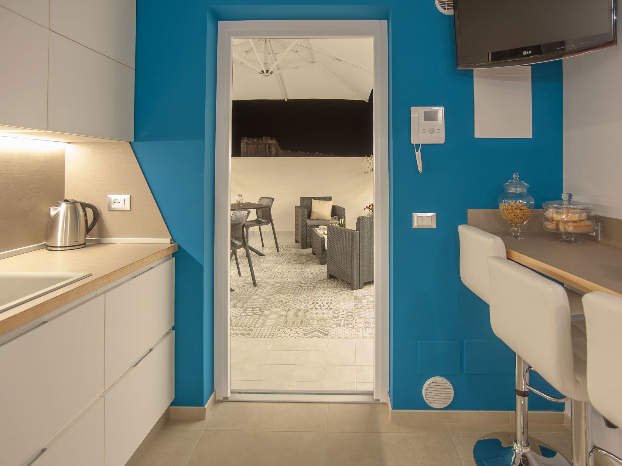 A modern kitchen with a kettle, a TV, and a coffee machine.