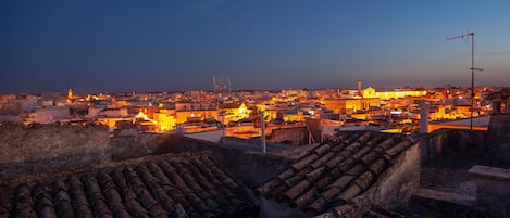 A cityscape at dusk with illuminated buildings and a prominent church.