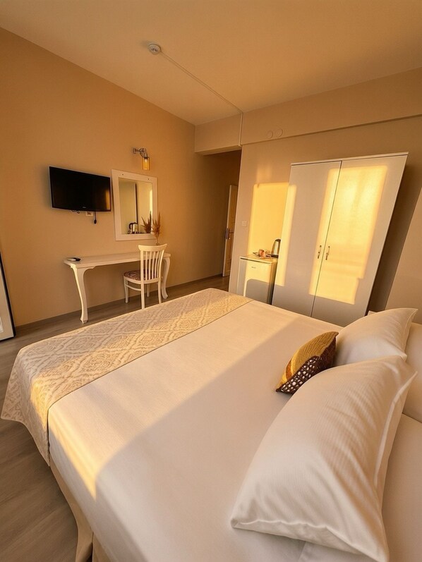 A hotel room with a bed, a desk, a television, and a wardrobe. - Yurekli Butik Otel (Marmara)