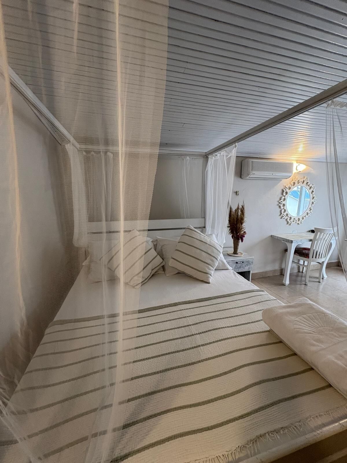 Een slaapkamer met een bed, een bureau en een stoel.