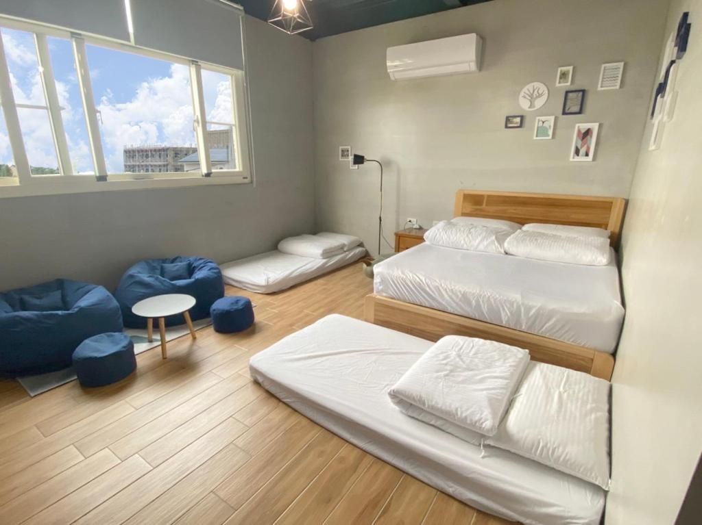 Una habitación con cama, escritorio, sillones de pie y ventana con vistas.