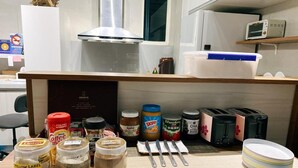 A kitchen counter with various food items, jars, and kitchen appliances. - Liuqiu Backpackers Hostel (Liuqiu)