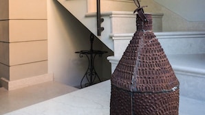 A staircase with a metal railing and a textured bottle-like object on a marble floor. - Corte Merighi Charming Rooms & Breakfast (Verona)