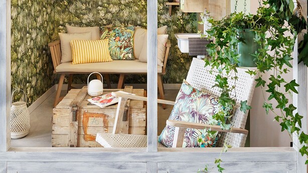 Une pièce chaleureuse et bien éclairée, avec un canapé, un fauteuil et une table, décorée de plantes et de guirlandes lumineuses.