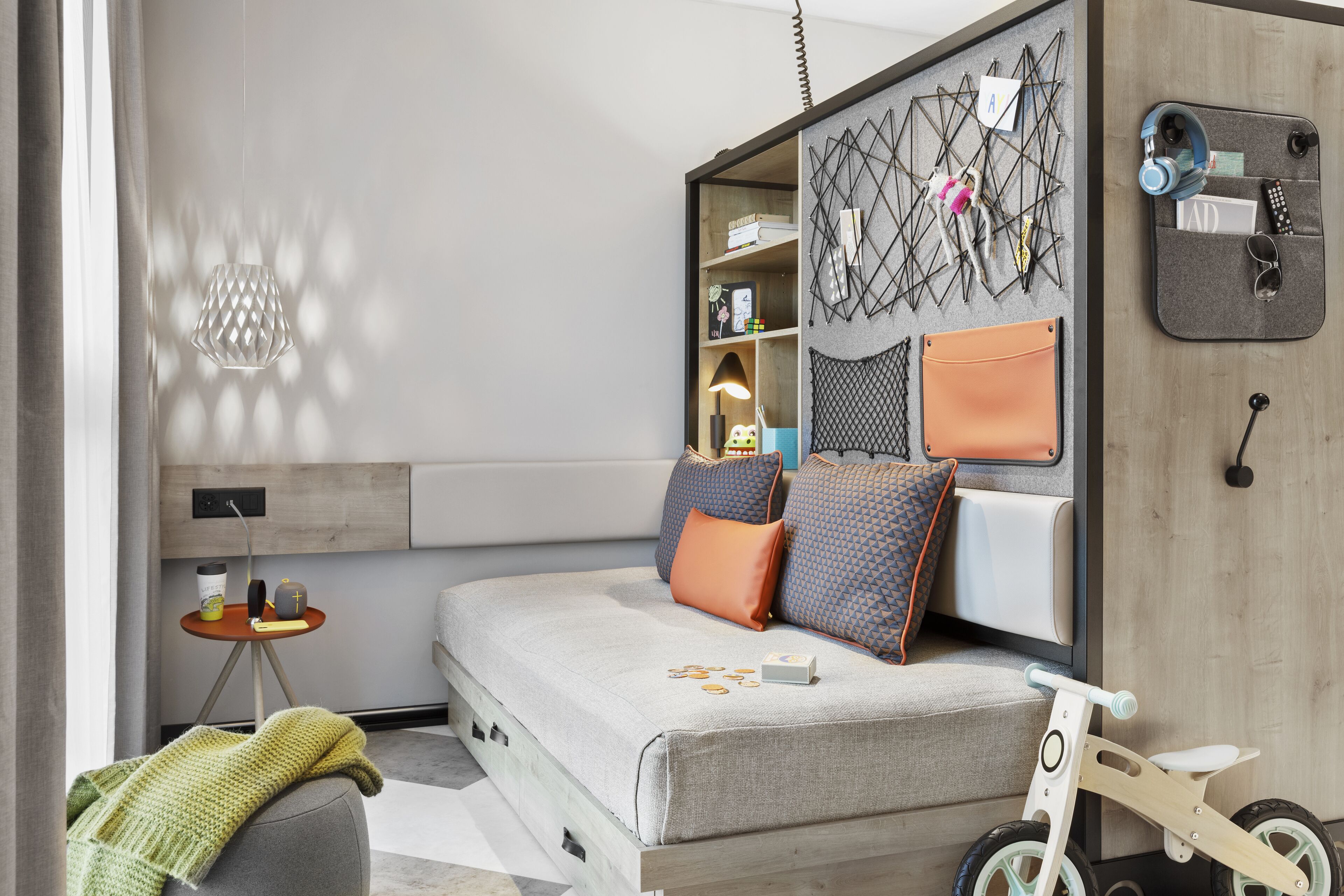 A modern bedroom with a bed, a small table, a chair, and a bike.
