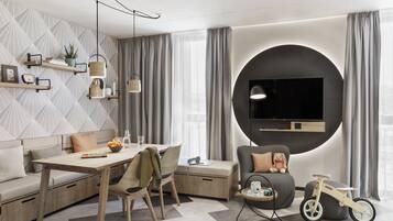 Una sala de estar moderna con un sofá, una mesa de comedor y un televisor montado en una pared circular.