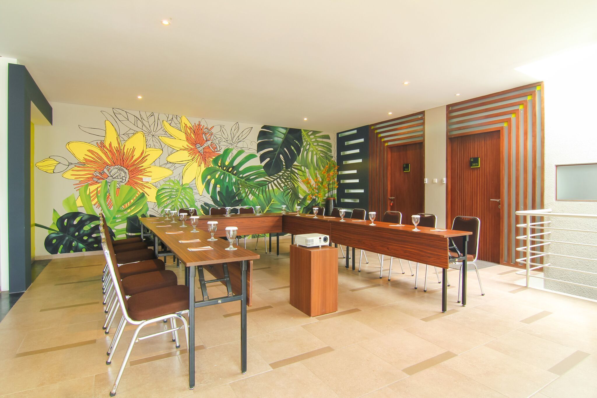 A conference room with a long table, chairs, and a projector.
