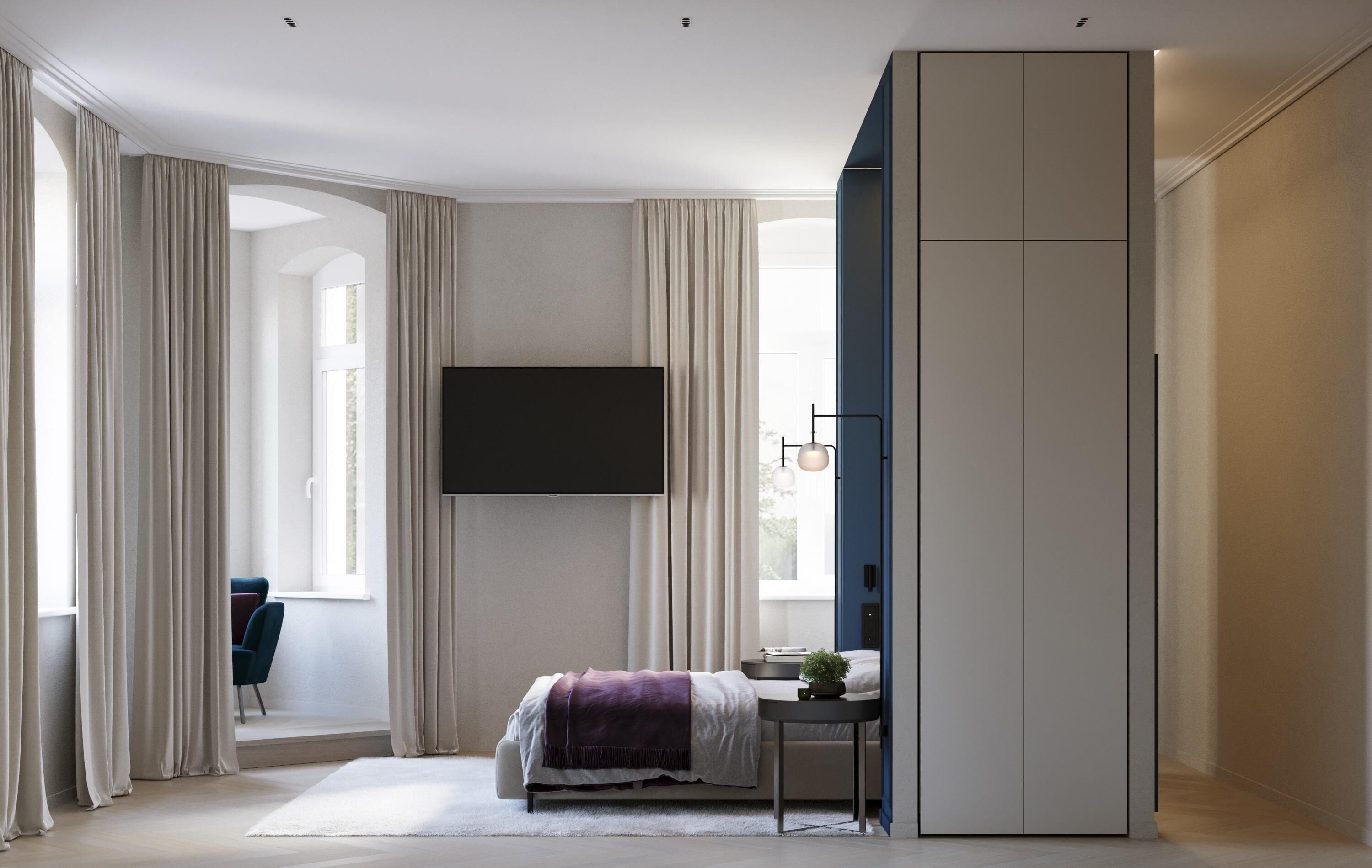 A bedroom with a bed, a TV, a desk with a plant, and a wardrobe.