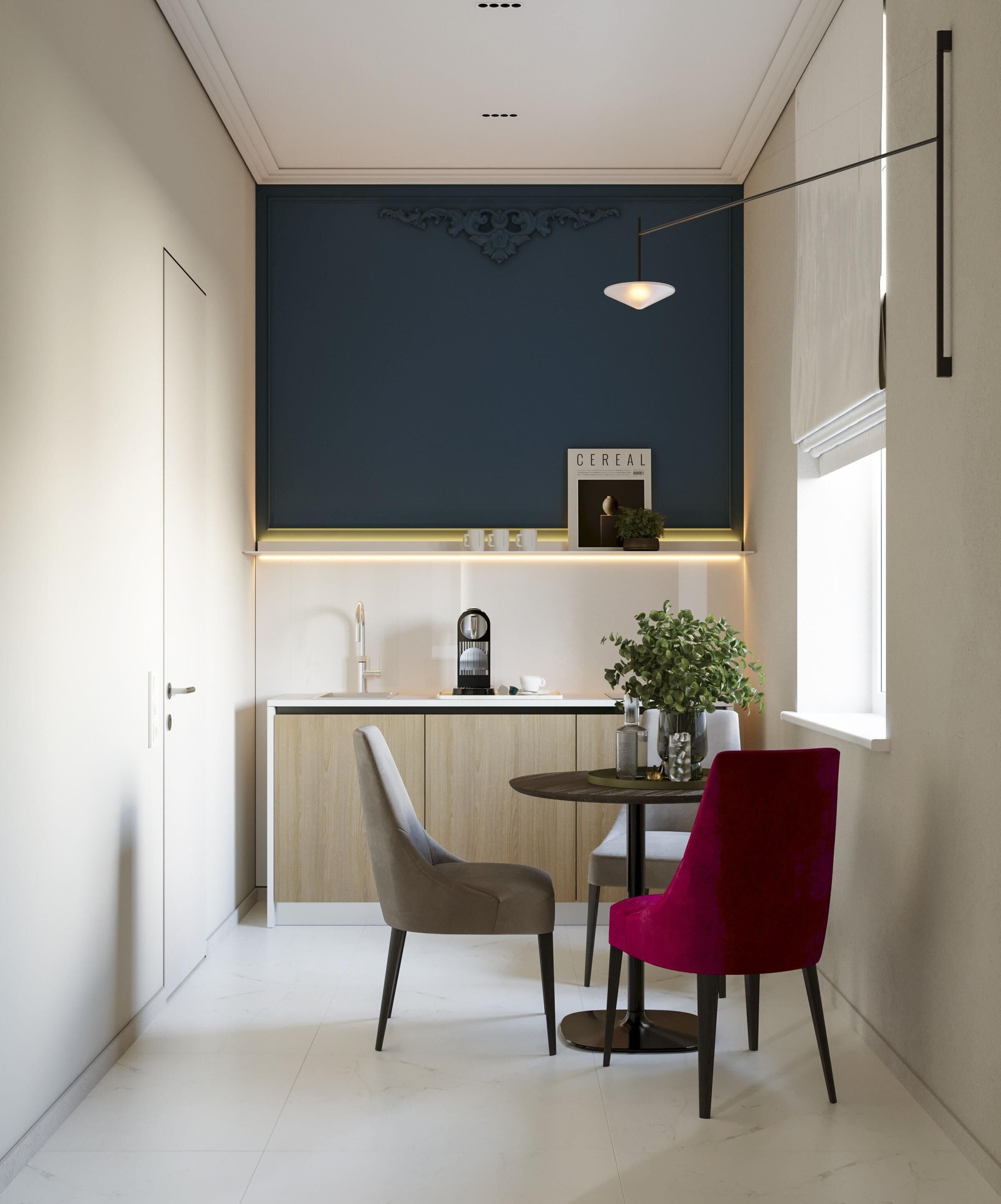 A modern kitchen with a dark accent wall, a coffee machine, a plant, and two chairs.