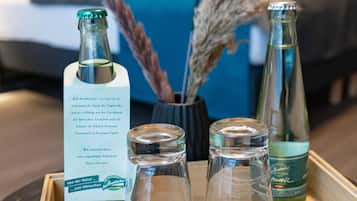 A tray with a bottle of Bad Brambach, a jar of massage oil, and two small glass bottles on a wooden table.