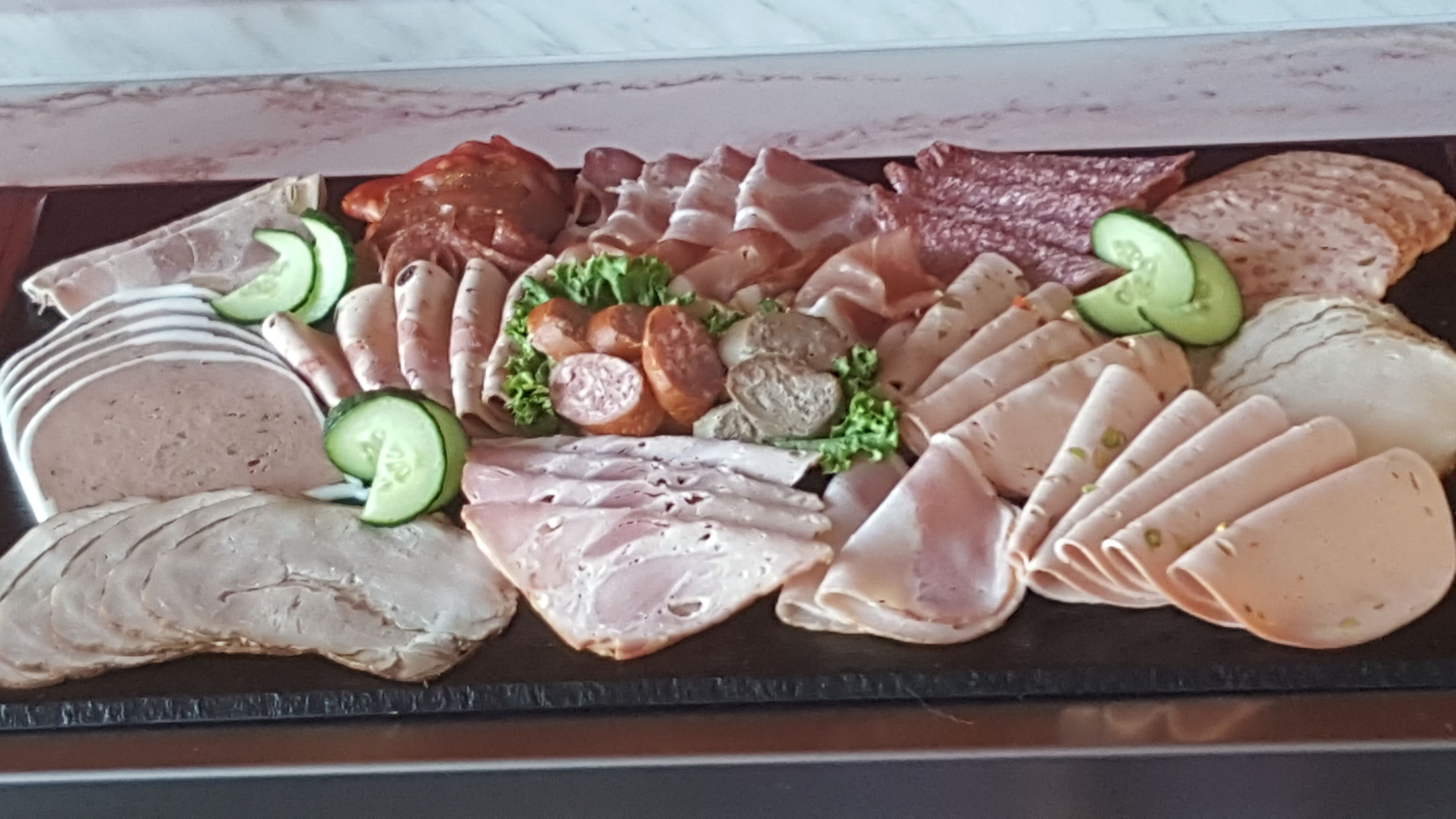 Een plateau met diverse soorten vleeswaren en kazen.