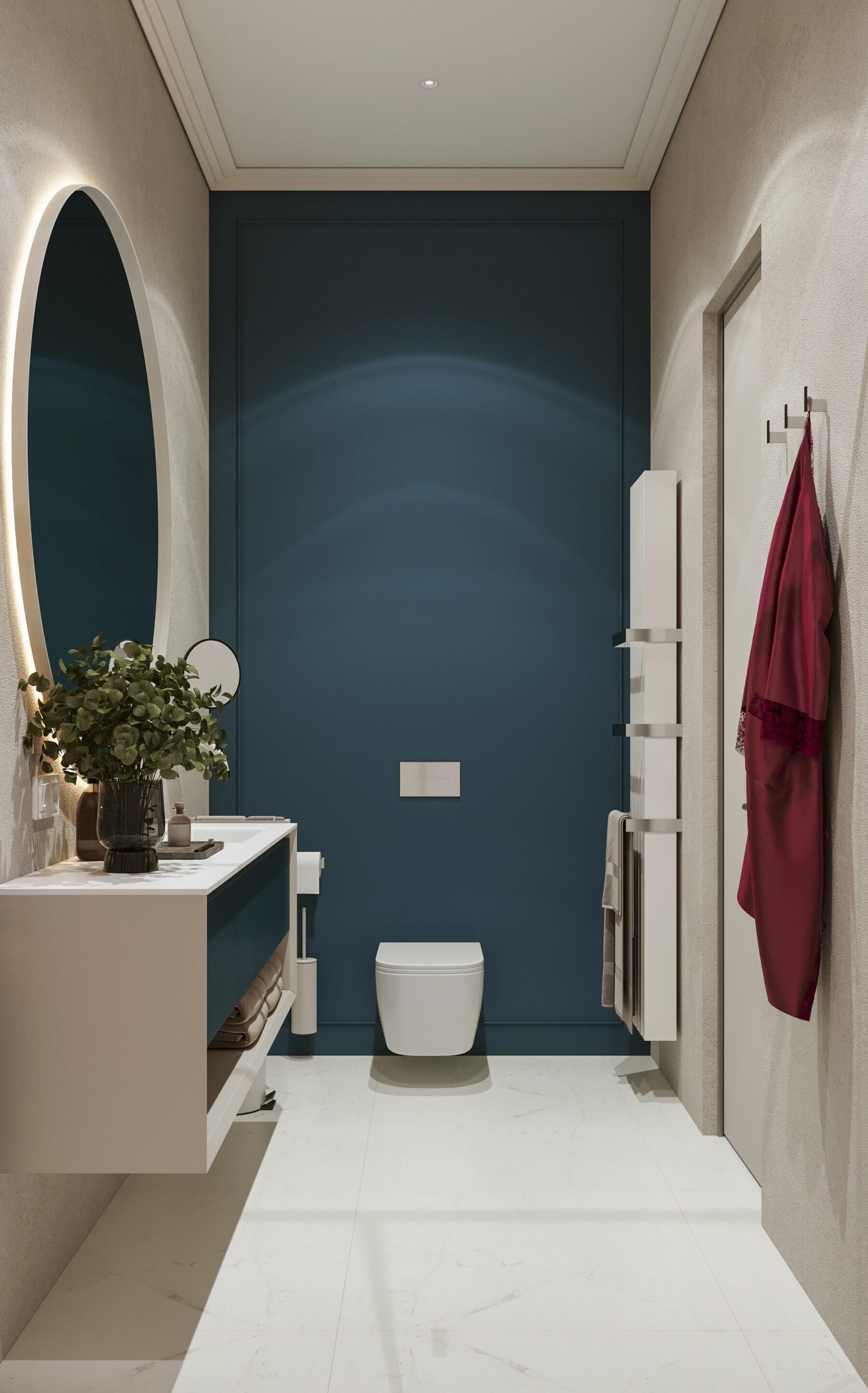 Un bagno moderno con un mobile lavabo bianco, uno specchio rotondo, un water bianco e un portasciugamani con un asciugamano rosso.