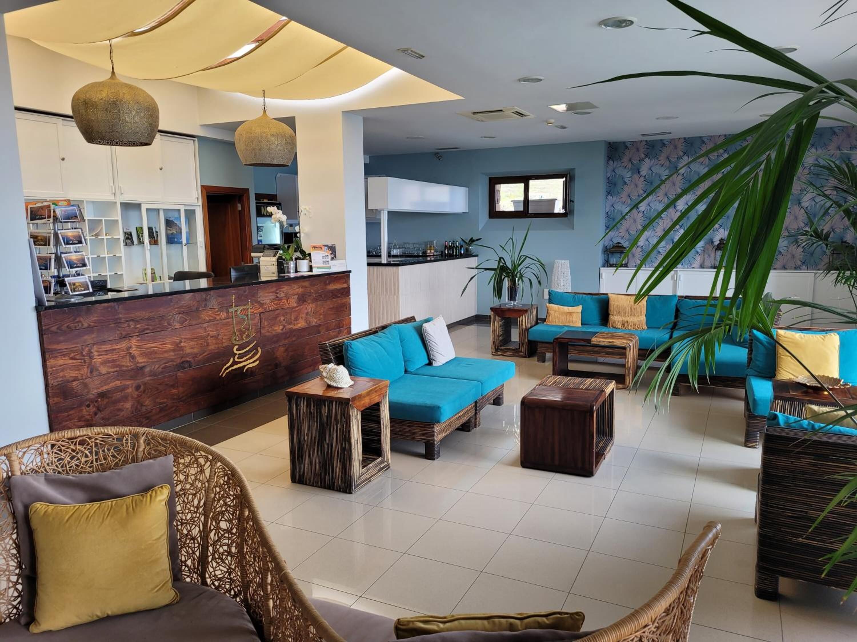 A modern lobby with a reception desk, seating area, and a large window.