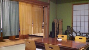 A traditional Japanese room with tatami flooring, a low wooden table, and cushions. - Numazu Ikkyuuan (Numazu)
