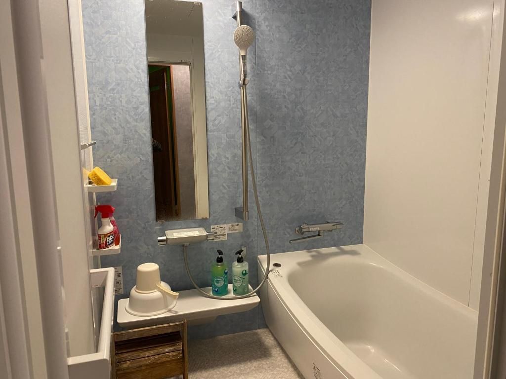 Un baño con bañera, ducha y espejo.