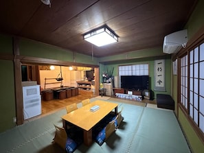 A traditional Japanese-style room with tatami flooring, a low table, and a television. - Numazu Ikkyuuan (Numazu)