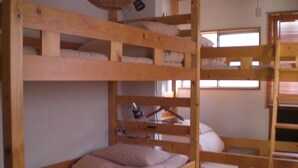 A bunk bed room with wooden frames, a hanging lamp, and a window with blinds. - Numazu Ikkyuuan (Numazu)