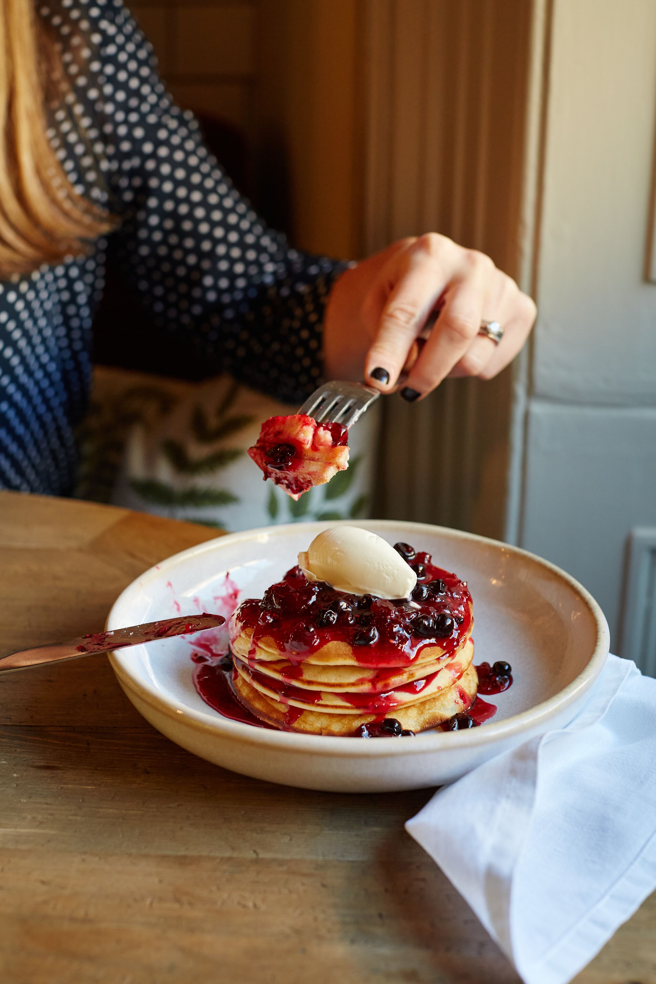 Ein Teller Pfannkuchen mit Beeren und Eis.