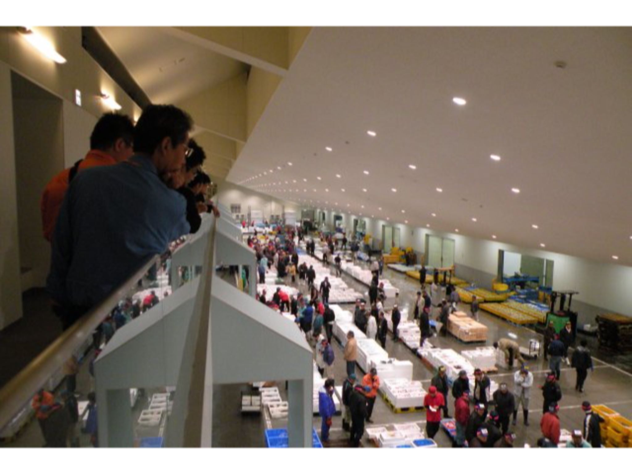 A spacious indoor market with multiple levels and a variety of goods on display.