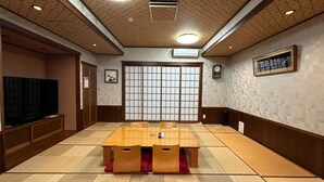 Une pièce de style japonais traditionnel, avec un sol recouvert de tatamis, une table basse et des portes coulissantes.
