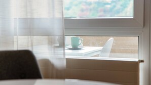 A view through a window with a table and a cup. - Pazzallo Apartments (Lugano)