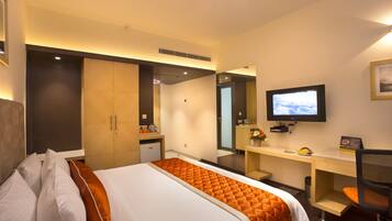 A hotel room with a bed, a desk, a television, and a mirror.