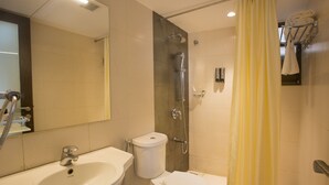 Un baño con lavabo, inodoro, ducha y espejo.