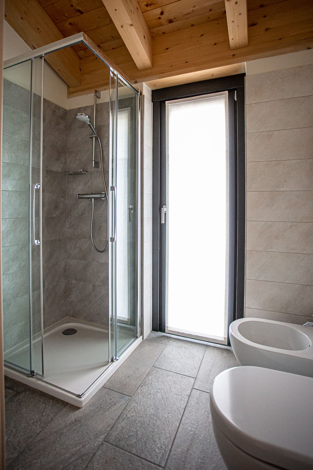 Un baño moderno con cabina de ducha de vidrio, un lavamanos amplio y una bañera.