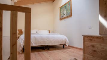 Un dormitorio con una cama de madera, una mesita de noche, un aparador de madera y un cuadro en la pared.
