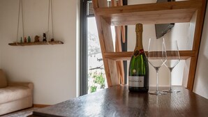 Une table en bois sur laquelle se trouvent une bouteille de champagne Bollinger et deux verres.