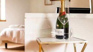 Una botella de champán Bollinger sobre una mesa pequeña con dos copas.