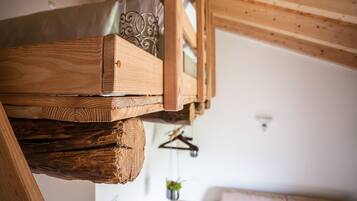 Een houten constructie met een hanglamp en een plantje op de achtergrond.