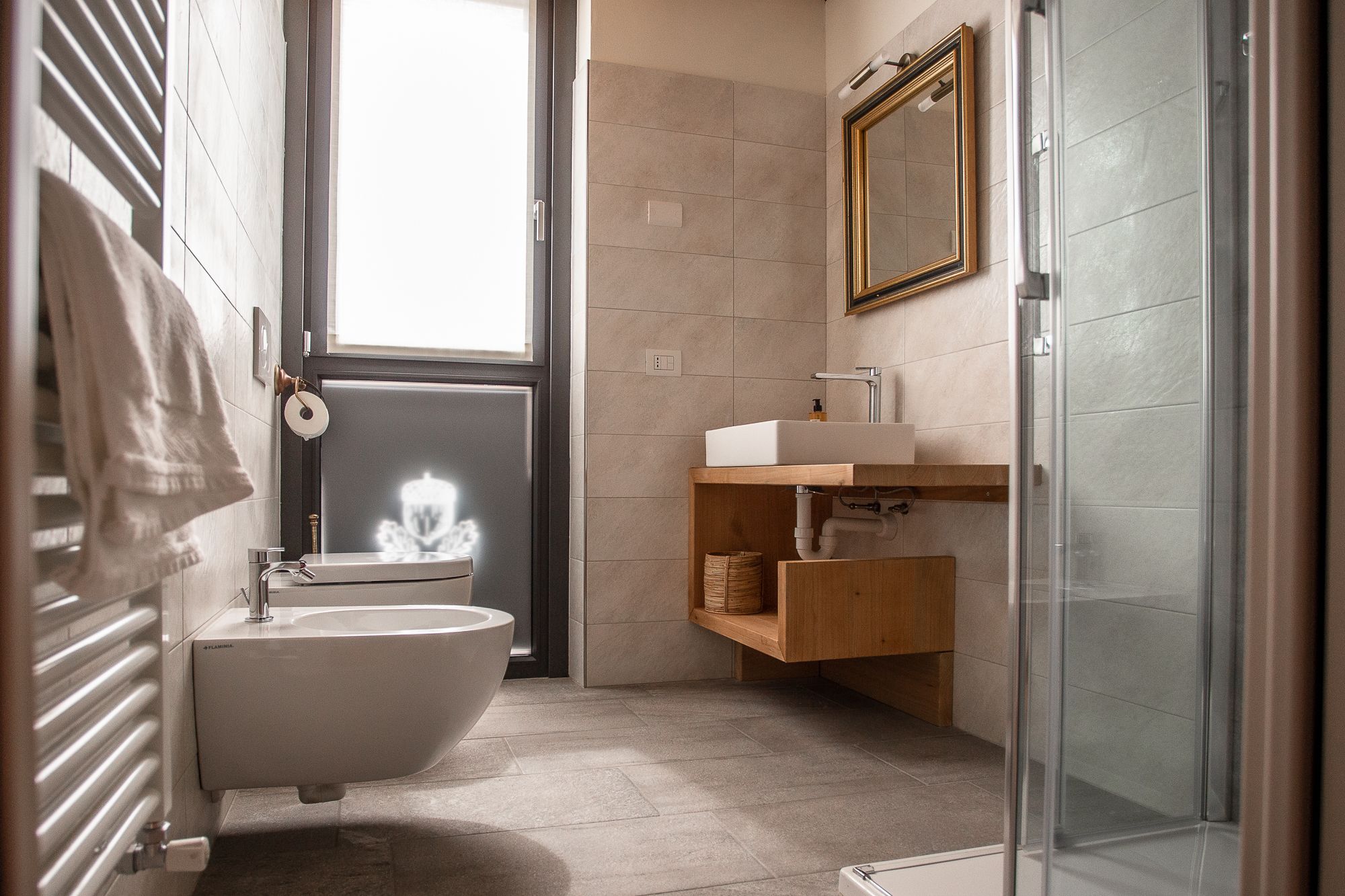 A modern bathroom with a freestanding bathtub, a sink with a wooden vanity, and a glass shower enclosure.