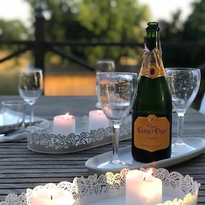 A bottle of Campo Viejo Cava on a tray with glasses and candles on a wooden table. - Lugna Gården- Spa & Konferens (Löberöd)