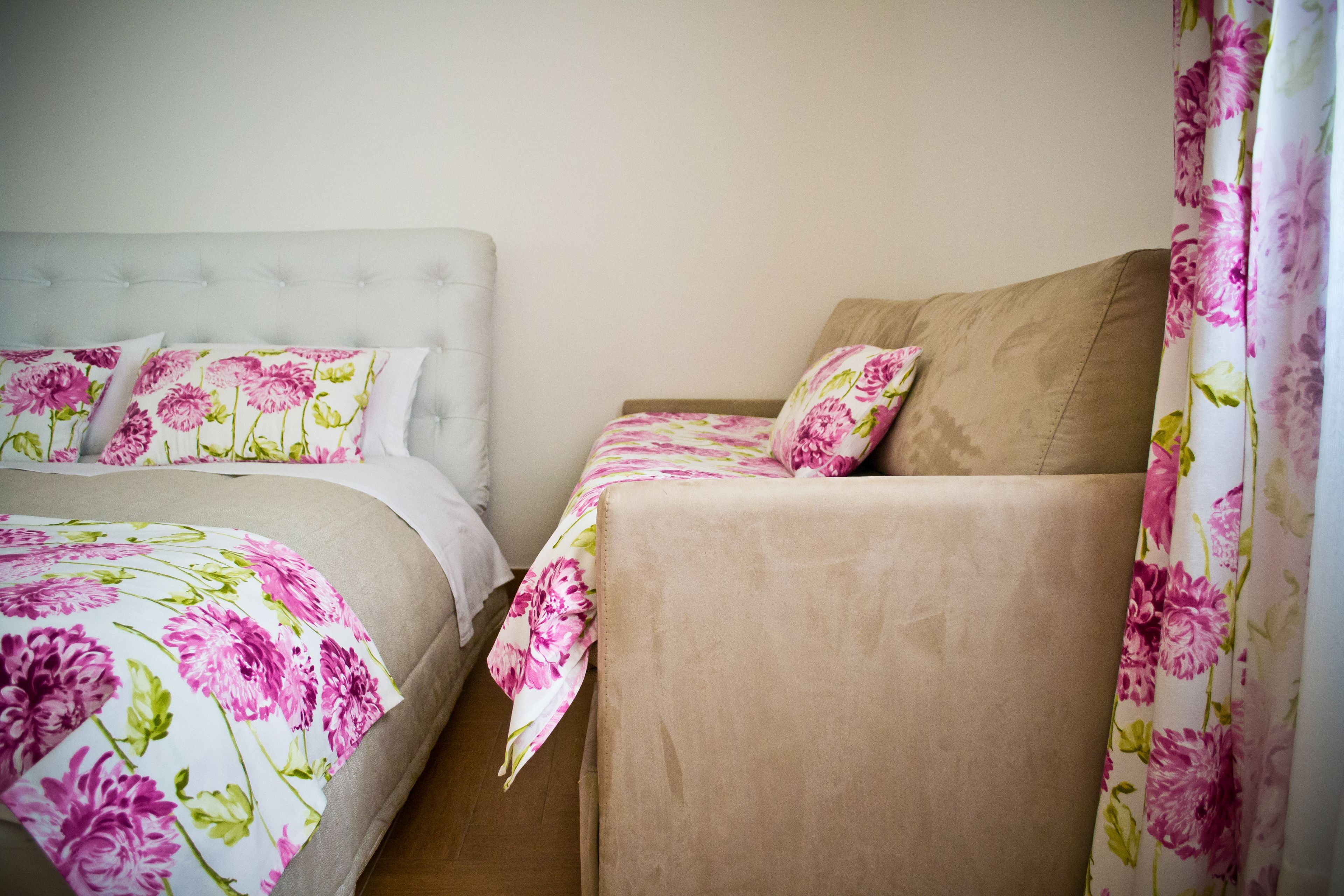 A bedroom with a bed and a sofa, both with floral bedding.