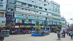 Un immeuble à plusieurs étages dont le rez-de-chaussée abrite différents commerces, notamment un magasin FamilyMart.