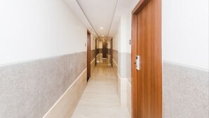 Corredor com portas de madeira e soalho ladrilhado.