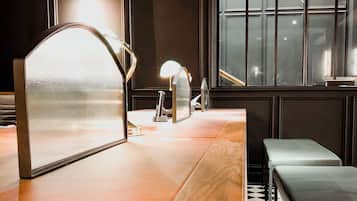 A room with a wooden counter, a mirror, a bench, and a window with a view.