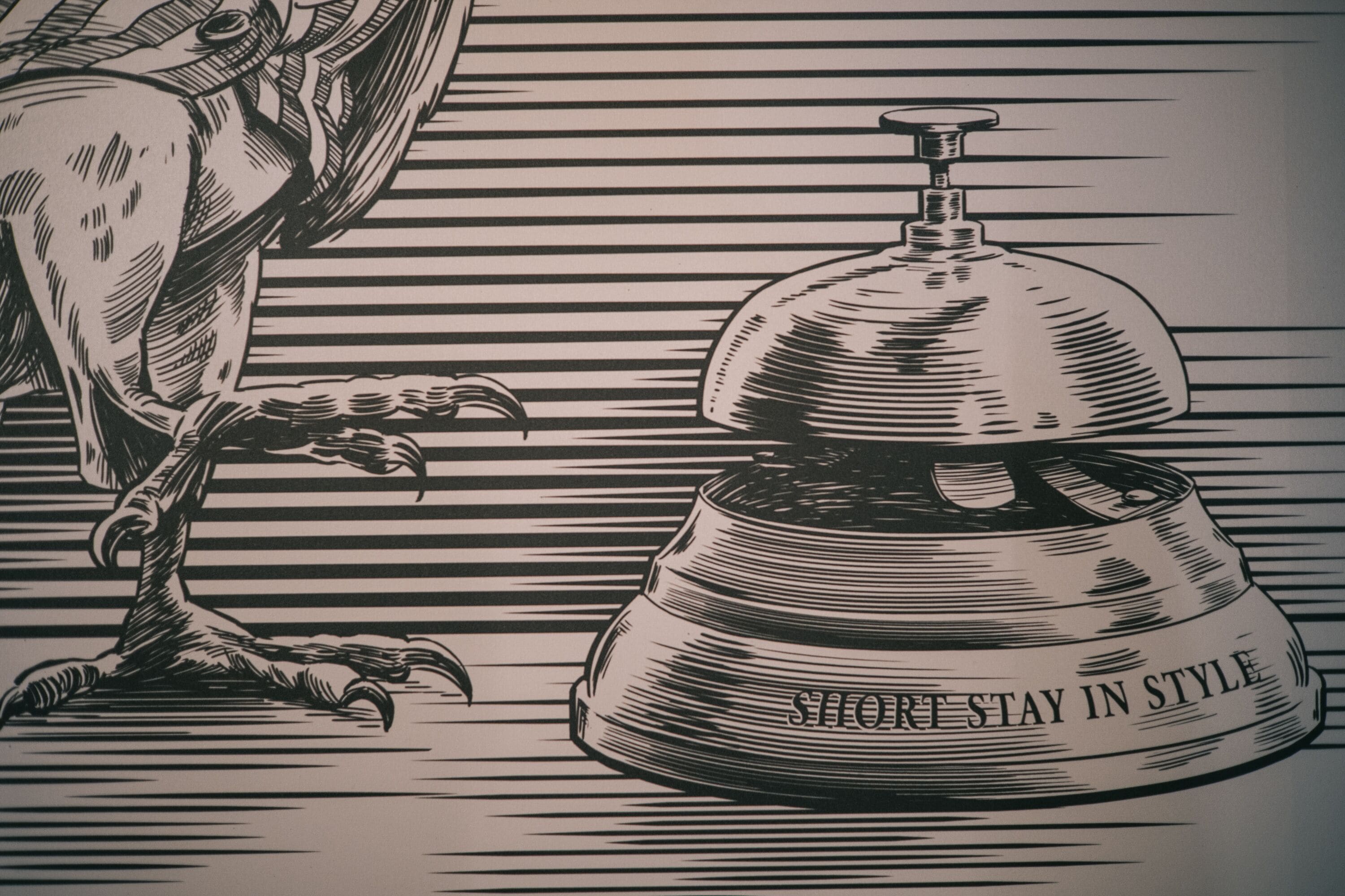 A stylized illustration of a hotel room with a large, ornate bed and a claw-footed chair.