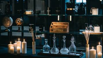 Una exhibición de velas, cristalería y una caja de madera con la etiqueta 'LETTERS' en una habitación con poca luz.