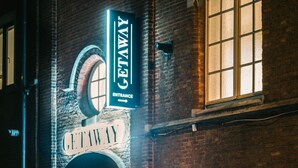 A brick building with a large illuminated sign reading "GETAWAY ENTRANCE".
