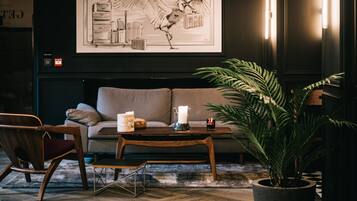 A modern living room with a sofa, wooden coffee table, and a potted plant.