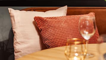 A cozy seating area with a wooden table, a glass of wine, and a candle.