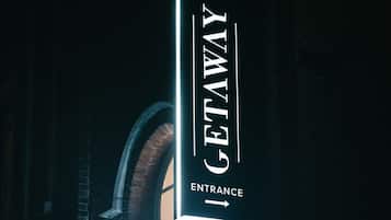A vertical sign with the words "GETAWAY ENTRANCE" and an arrow pointing right.