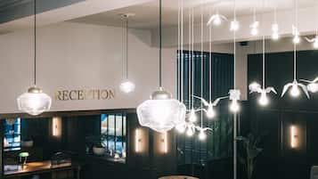 A reception area with a checkered floor, wooden furniture, and hanging pendant lights.