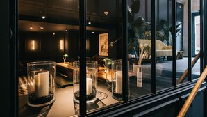 A room with a large window, a table with candles, and a view of the outside.