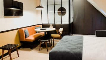 Een moderne hotelkamer met een bed, een bank, een tafeltje en een stoel.