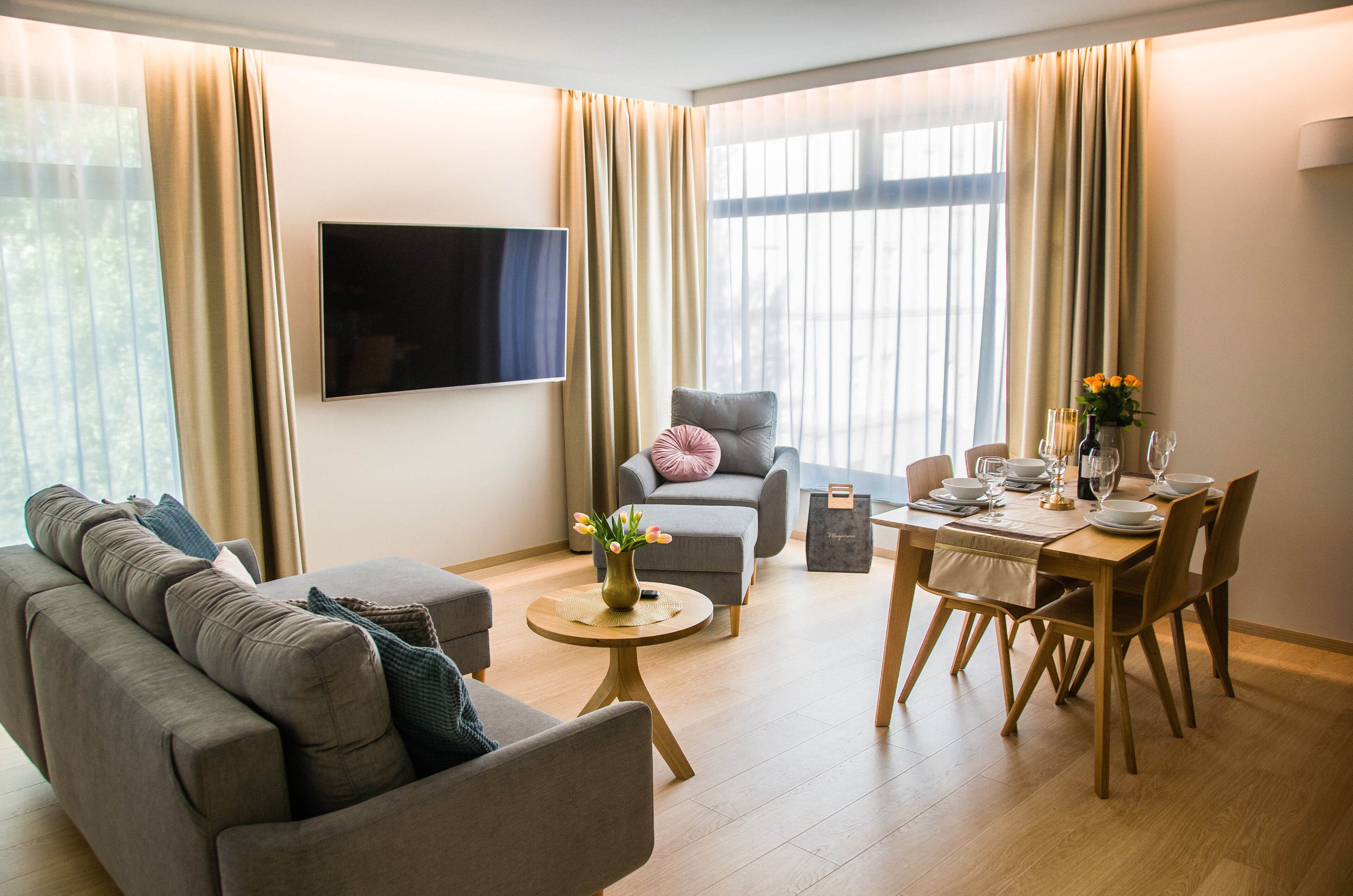 Un salon moderne avec un canapé, un fauteuil et une table à manger pour quatre personnes.